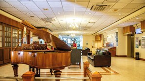Ett stort flygel i en rymlig lobby med en kristallkrona, en receptionsdisk och en sittgrupp.