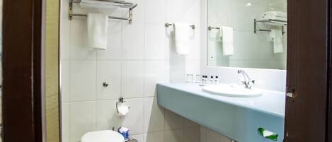 A bathroom with a toilet, sink, and towel rack.