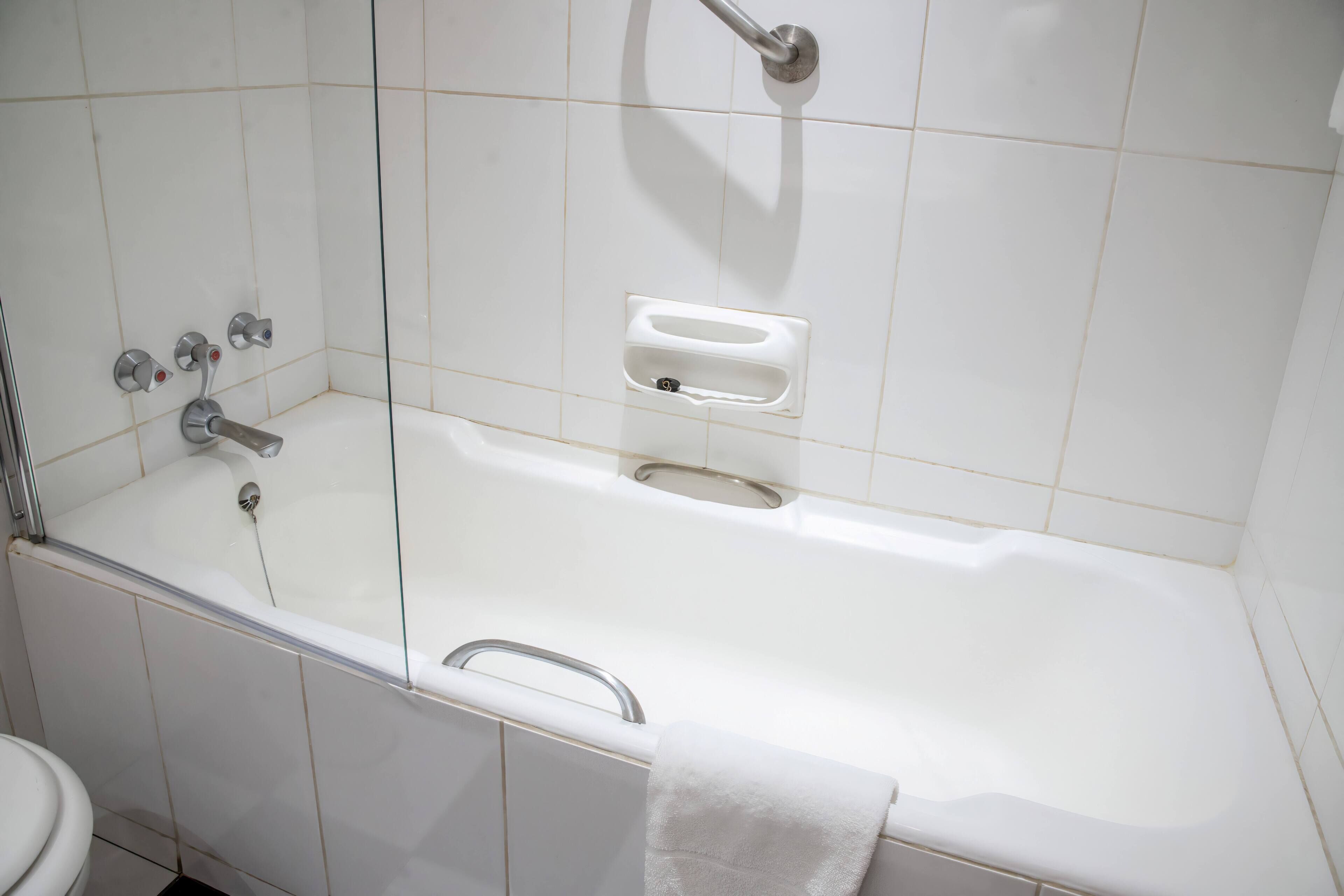 A bathroom with a bathtub, a toilet, and a glass shower enclosure.