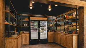 A compact, well-organized kitchen with wooden cabinetry, a built-in refrigerator, and shelves stocked with various items. - The Ozarker Lodge (Branson)