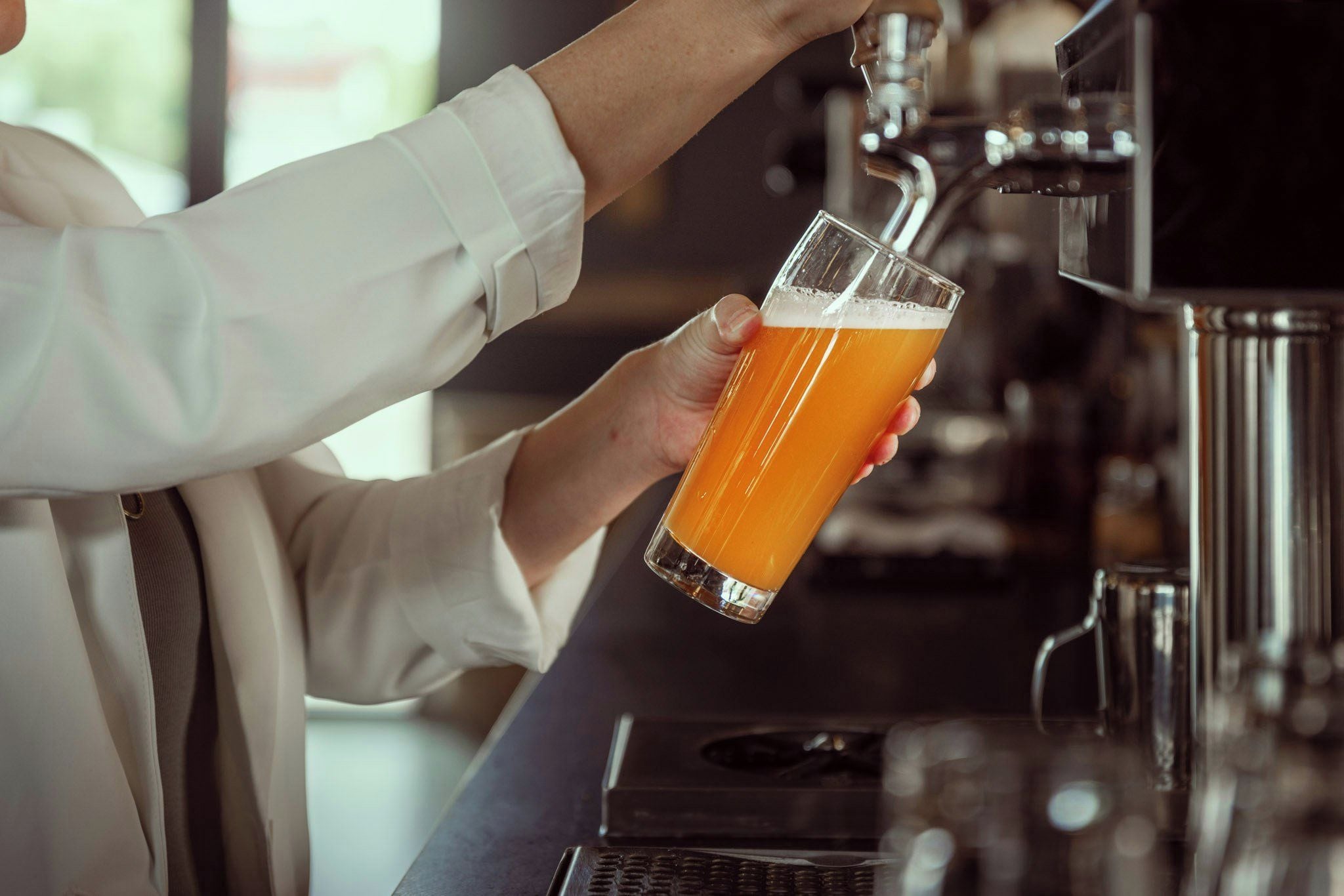 Una persona sosteniendo una jarra de cerveza en un bar.