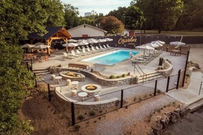 A pool area with lounge chairs, a fire pit, and a fenced deck.
