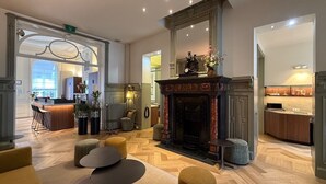 A spacious lobby with a fireplace, seating area, and a bar. - Hotel Du Congres (Brussels)