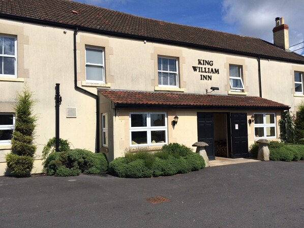 A building labeled "King William Inn" with a tiled roof, multiple windows, and a front door.