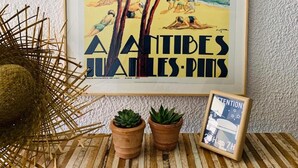 A framed poster of a beach scene with trees and the word "HIVER" at the top. - Hotel Le Petit Castel (Antibes)