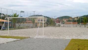 A soccer field with a goalpost and a fence.