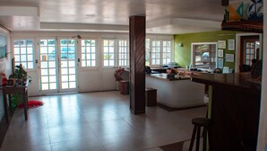 A spacious kitchen with a central island, large windows, and a green accent wall. - Pousada Luar de Buzios (Búzios)