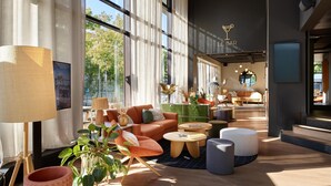 Un espace lounge moderne doté de grandes fenêtres, de sièges confortables et d’une enseigne indiquant la présence d’un bar.