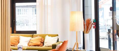 En modern inredning med en soffa, fåtöljer, en lampa och hängande lampor.