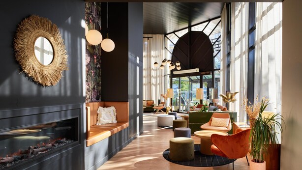 Un intérieur moderne avec une cheminée, un coin salon et de grandes fenêtres.