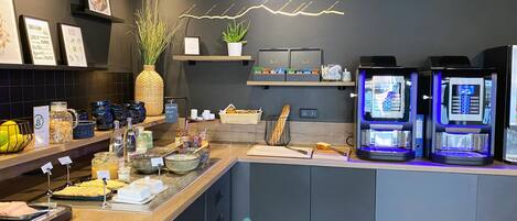 Un moderno café con mostrador, máquinas de café y diversas opciones para el desayuno.