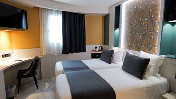 Una camera d'albergo con un letto, una scrivania, una sedia e una televisione.
