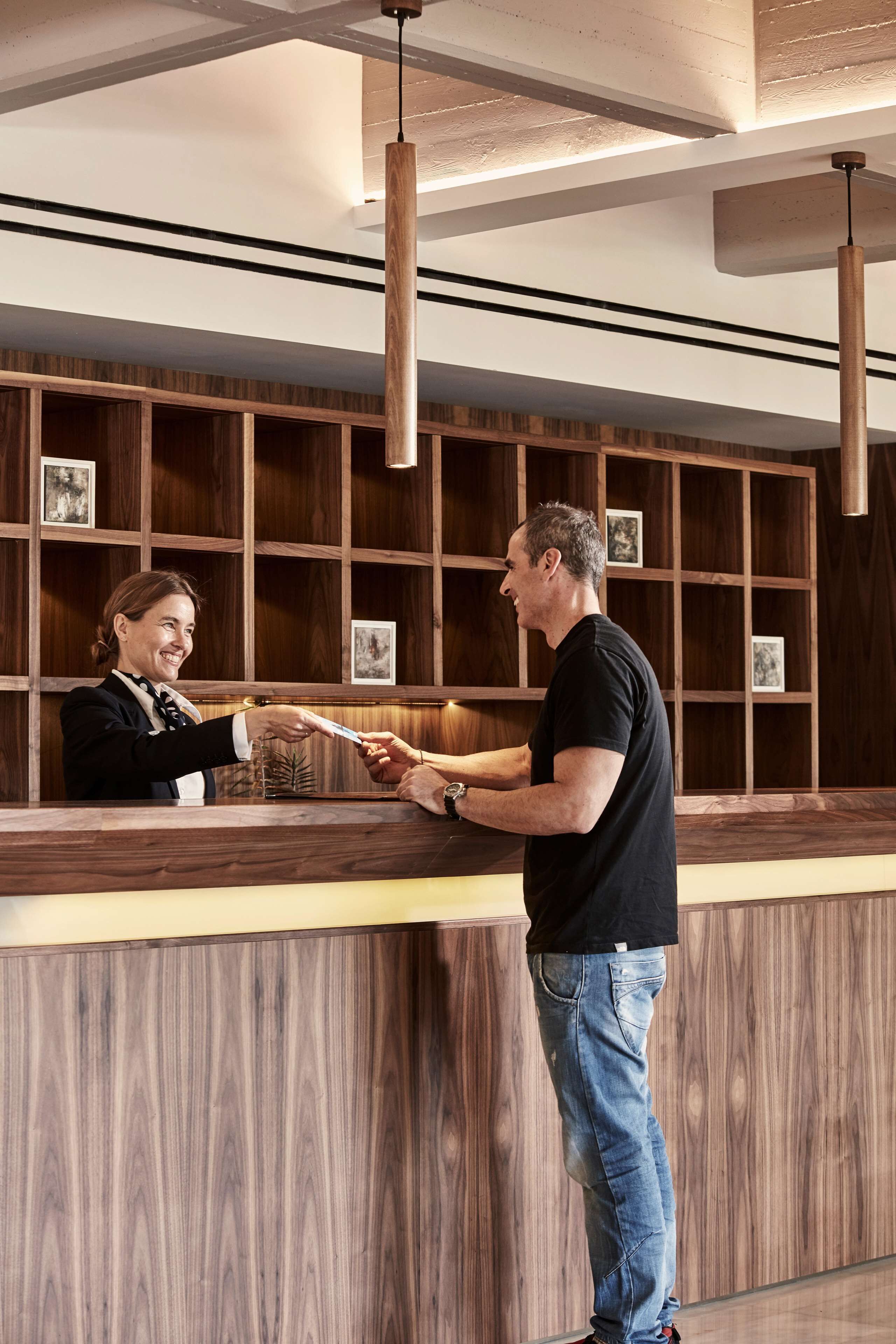 A reception desk with a wooden panel design and framed pictures on the wall.