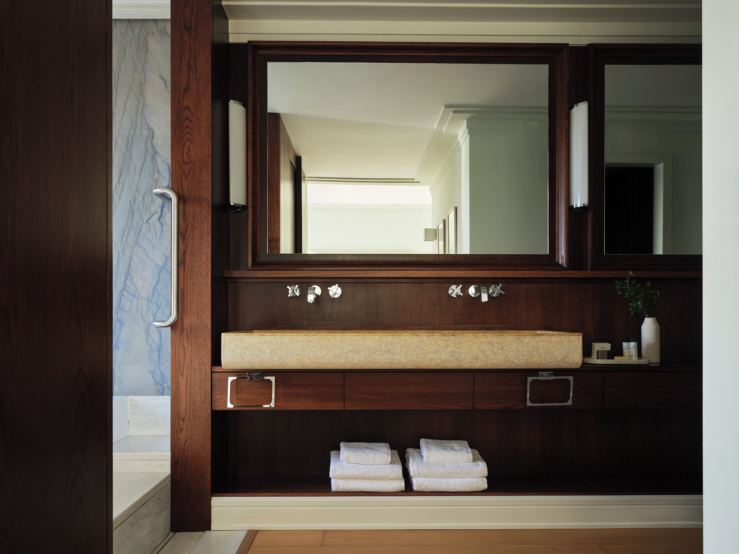 A bathroom with a double vanity, two sinks, and a large mirror.