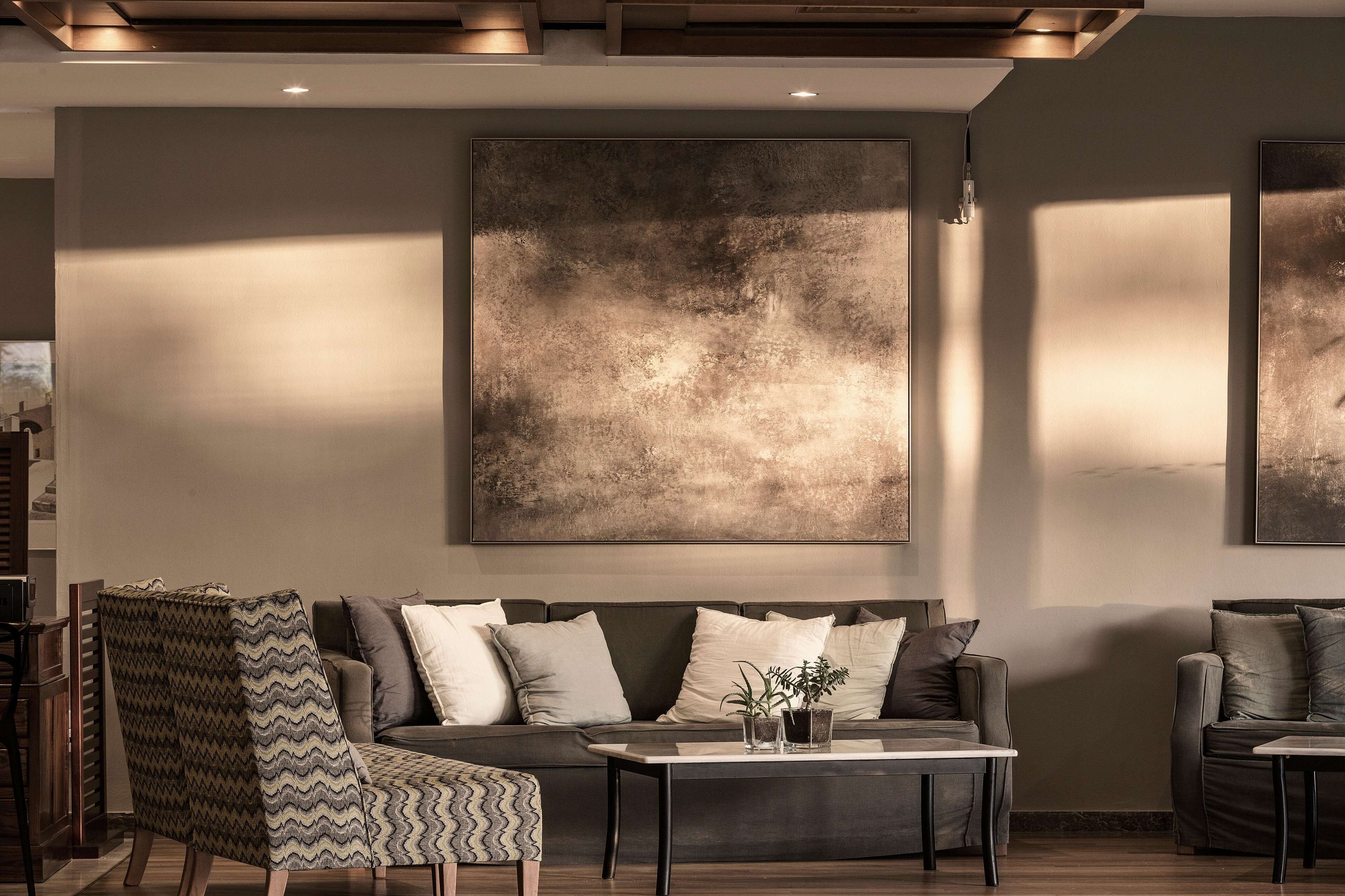 A modern living room with a sofa, armchairs, and a coffee table.
