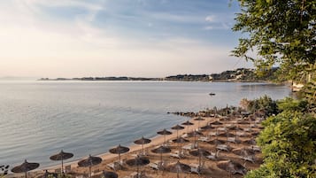 På stranden, vit sandstrand, solstolar och parasoller