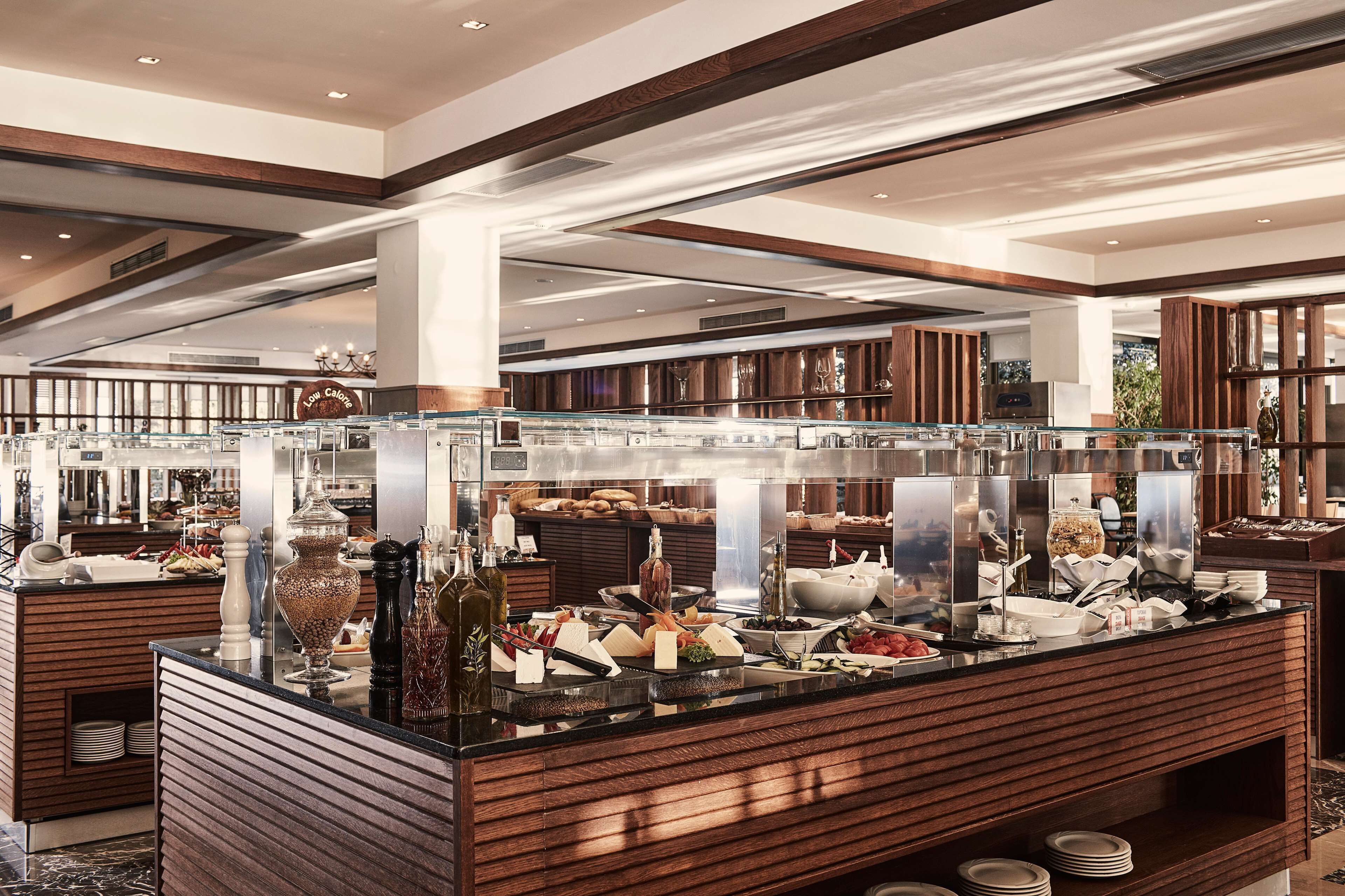 A buffet with a variety of food items and a wooden counter.