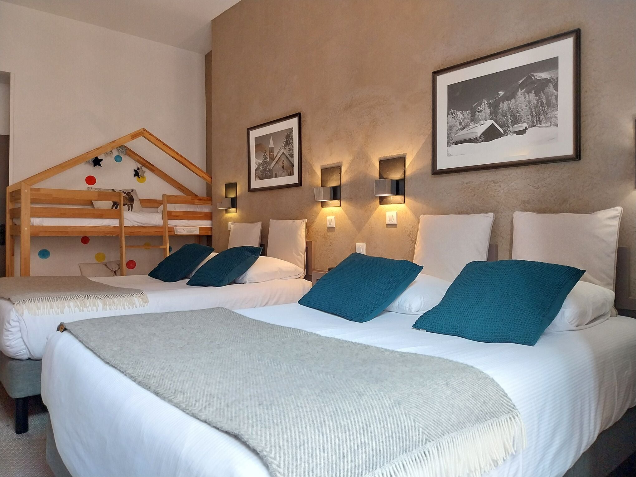 Een hotelkamer met twee bedden, een stapelbed en een groot raam.