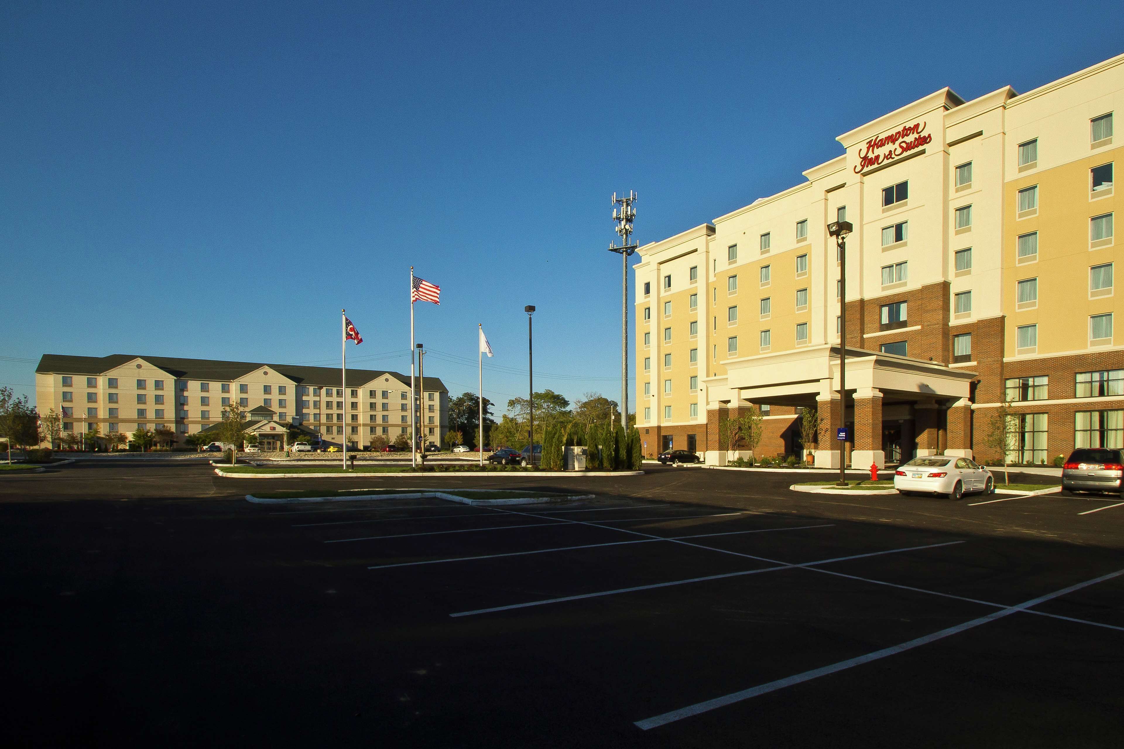 A large hotel with multiple floors and a parking lot.