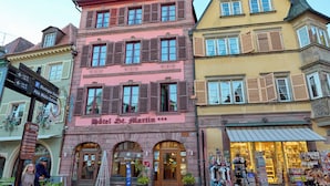 Fachada de un hotel con un letrero que dice "Hotel St. Martin" y una tienda con varios artículos a la vista.