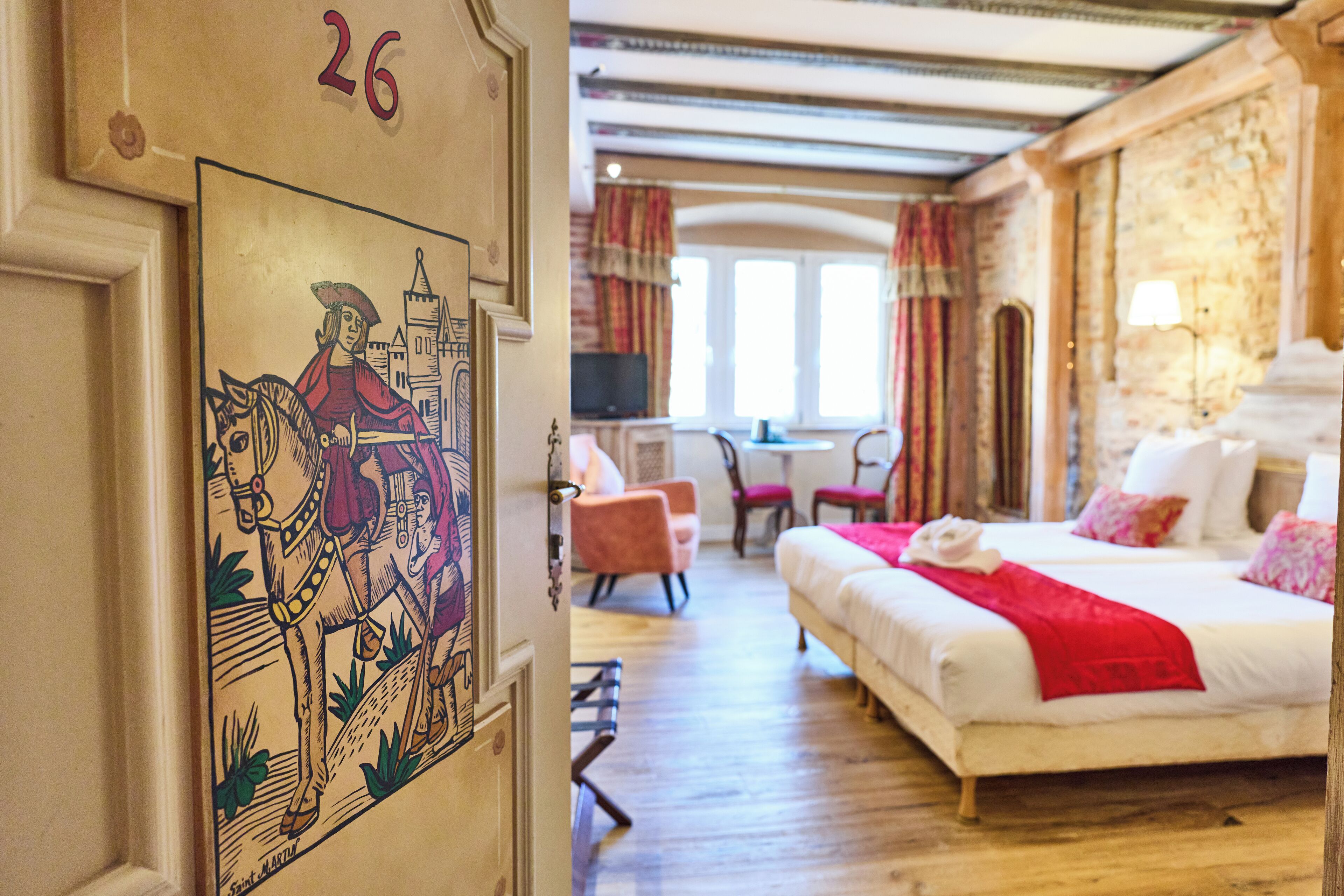 Una habitación de hotel con una cama, un escritorio y una silla.