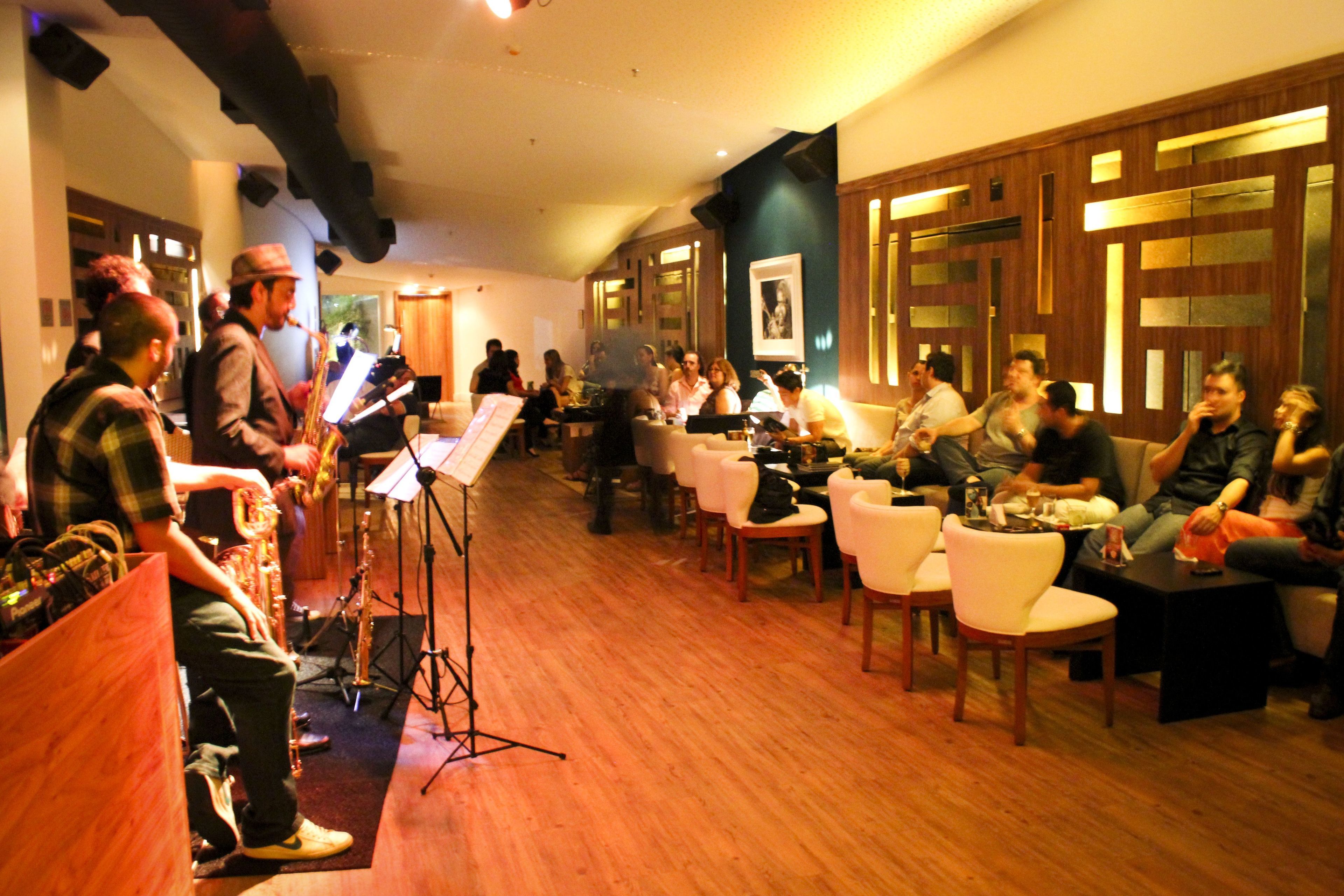 A room with a piano, chairs, and a group of people.