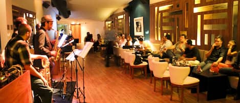A room with a piano, chairs, and a group of people.