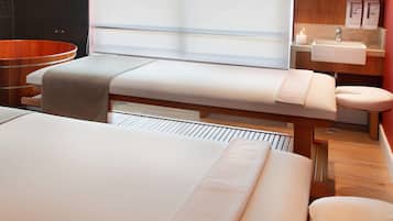 Relax in a serene space with a large bathtub, massage table, and comfortable seating.