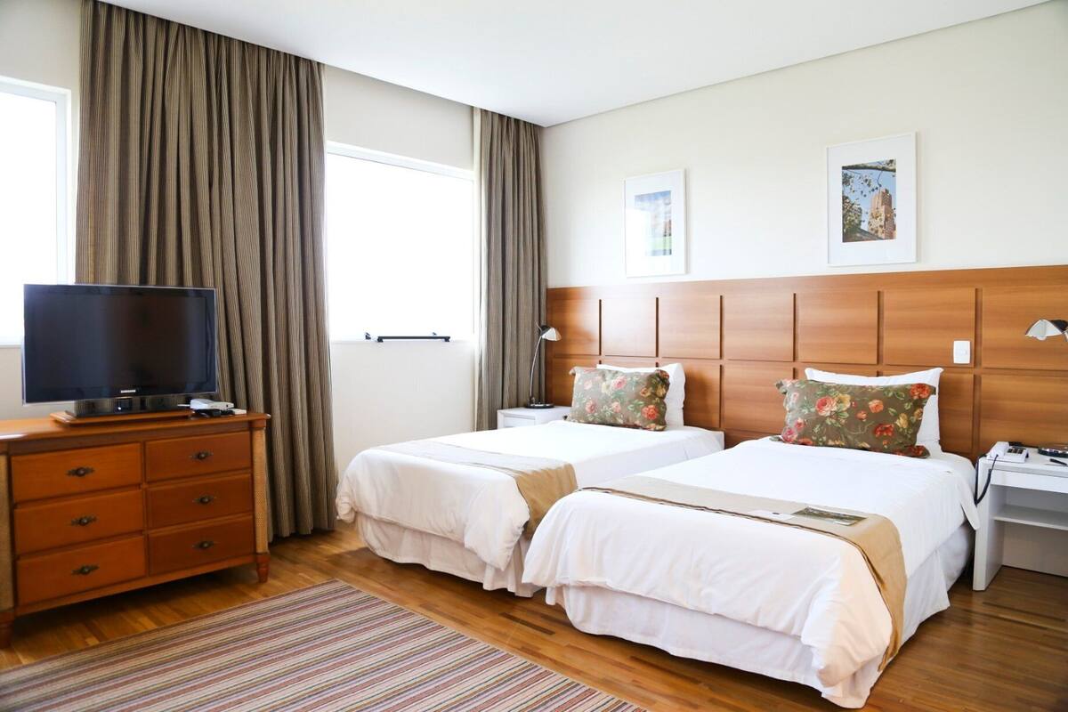 Twin kamer | Een minibar, een kluis op de kamer, een bureau, verduisterende gordijnen