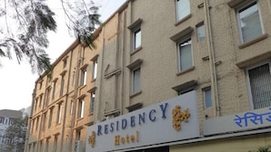 A multi-story building with a sign reading "Residency Hotel".