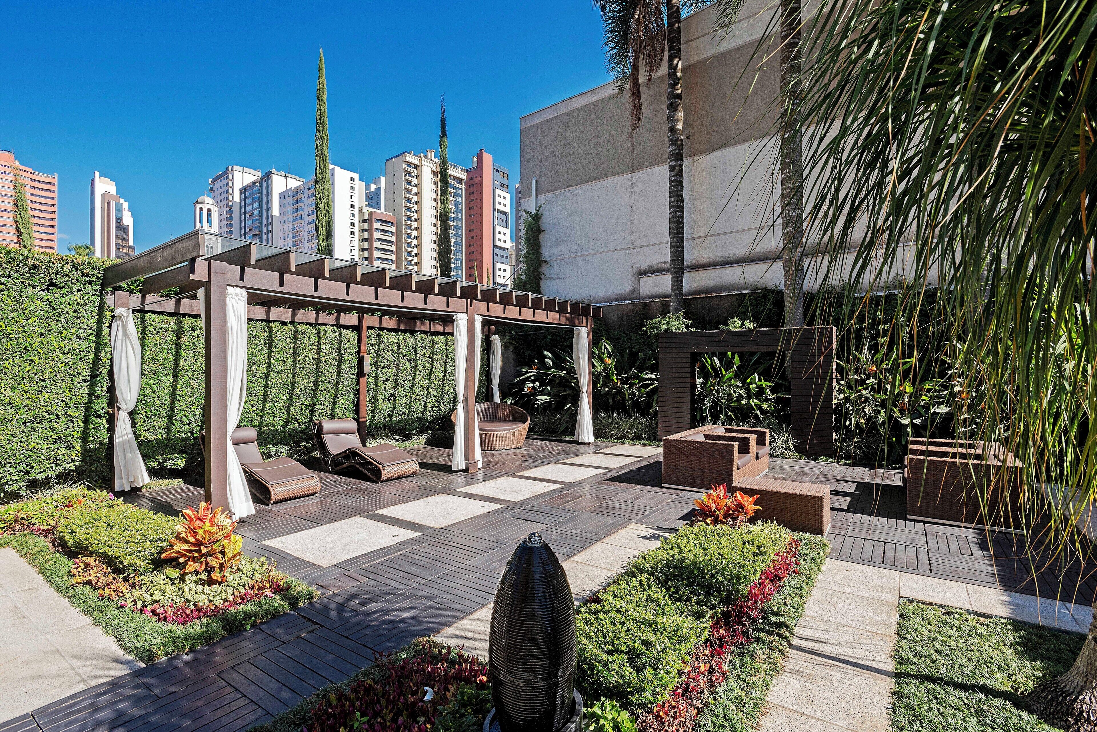 Un jardin sur le toit agrémenté d’une pergola, de coins salon et d’une variété de plantes.