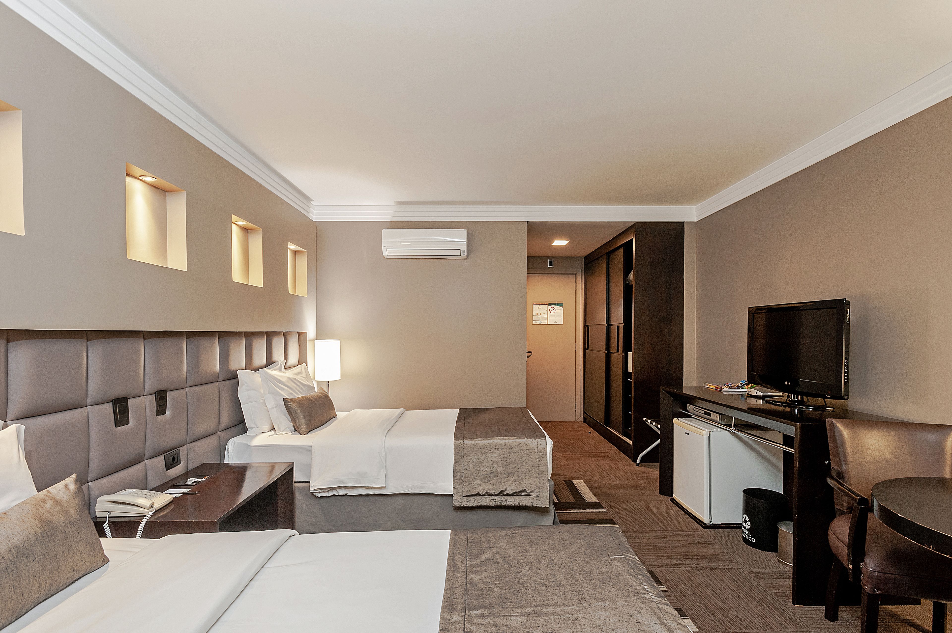 Une chambre d’hôtel avec deux lits, un bureau, une télévision et une petite kitchenette.