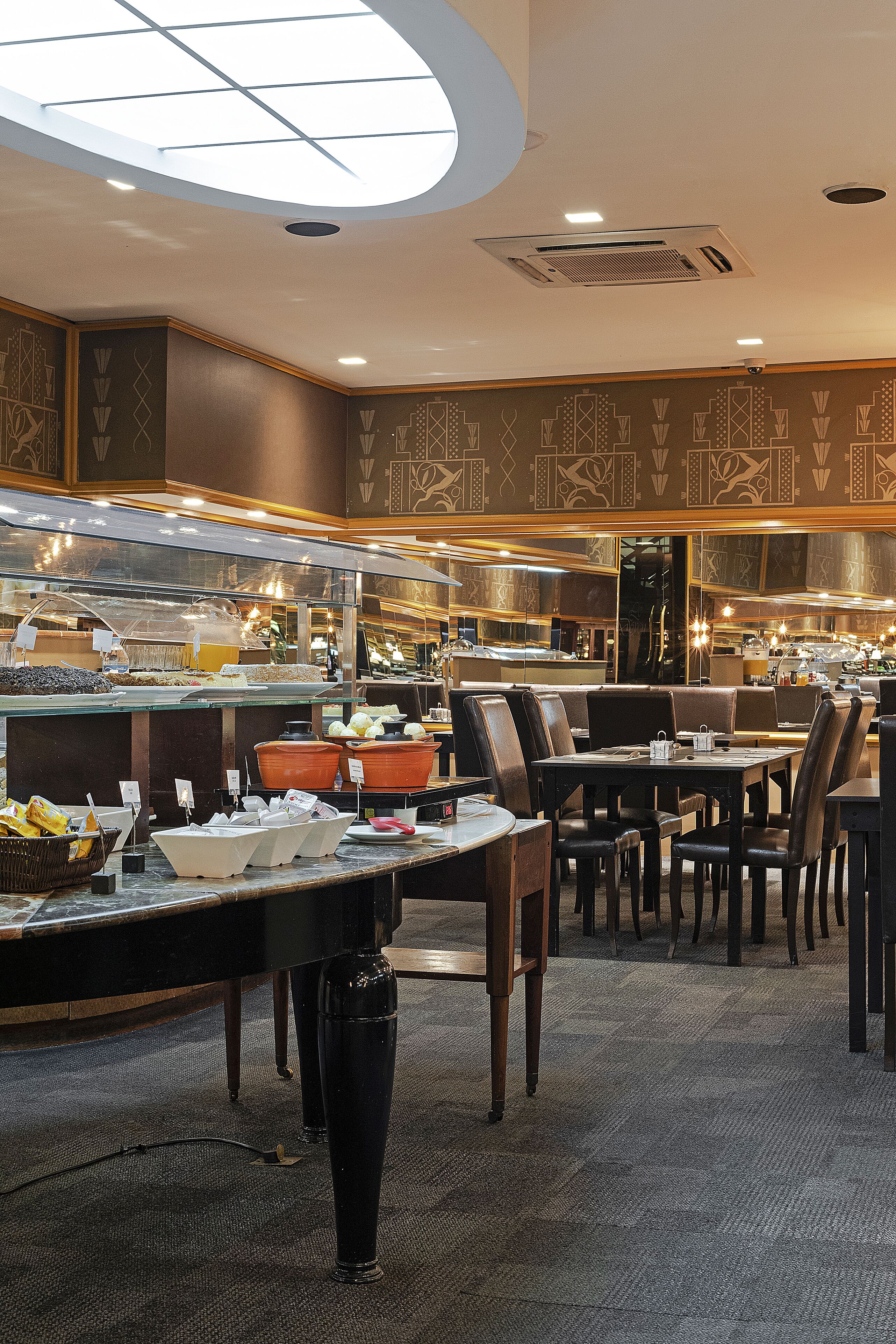 A buffet area with multiple serving stations, seating arrangements, and a ceiling with a skylight.