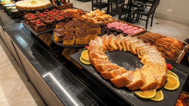 Un bufé con diversos postres y pastelería.