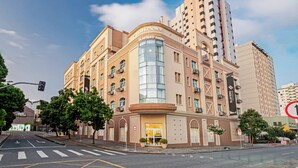 Un hotel con fachada curva, ventanas amplias y una entrada destacada.
