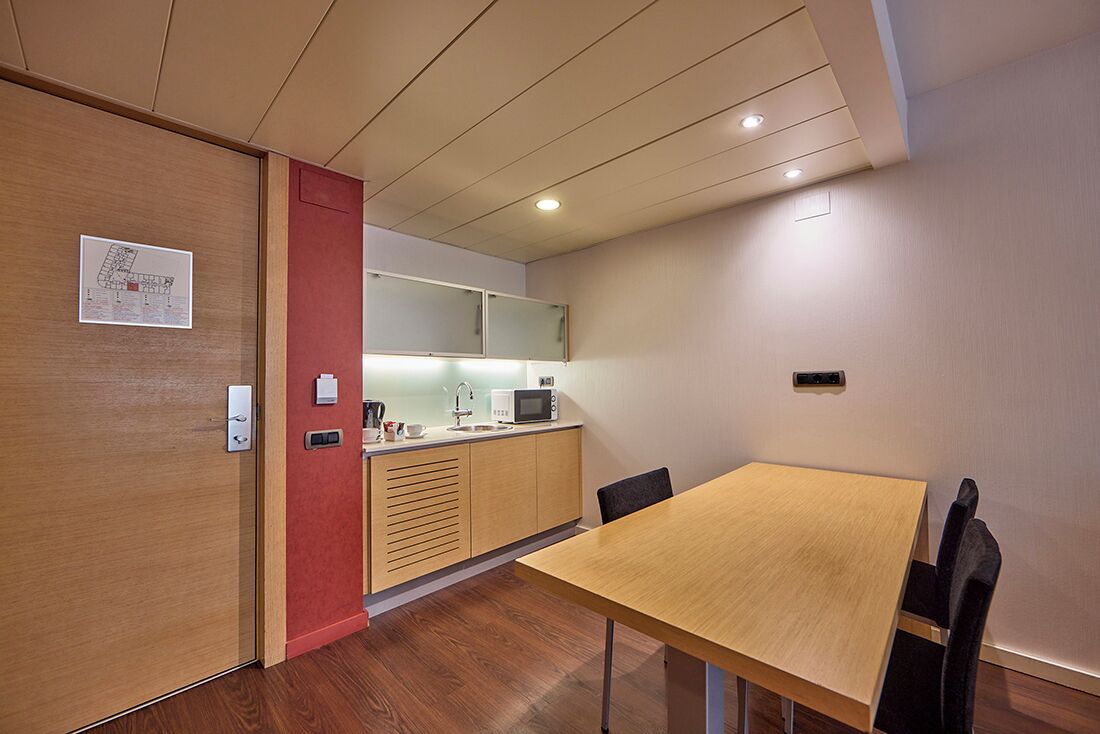 A modern kitchen with wooden cabinets, a microwave, and a sink.