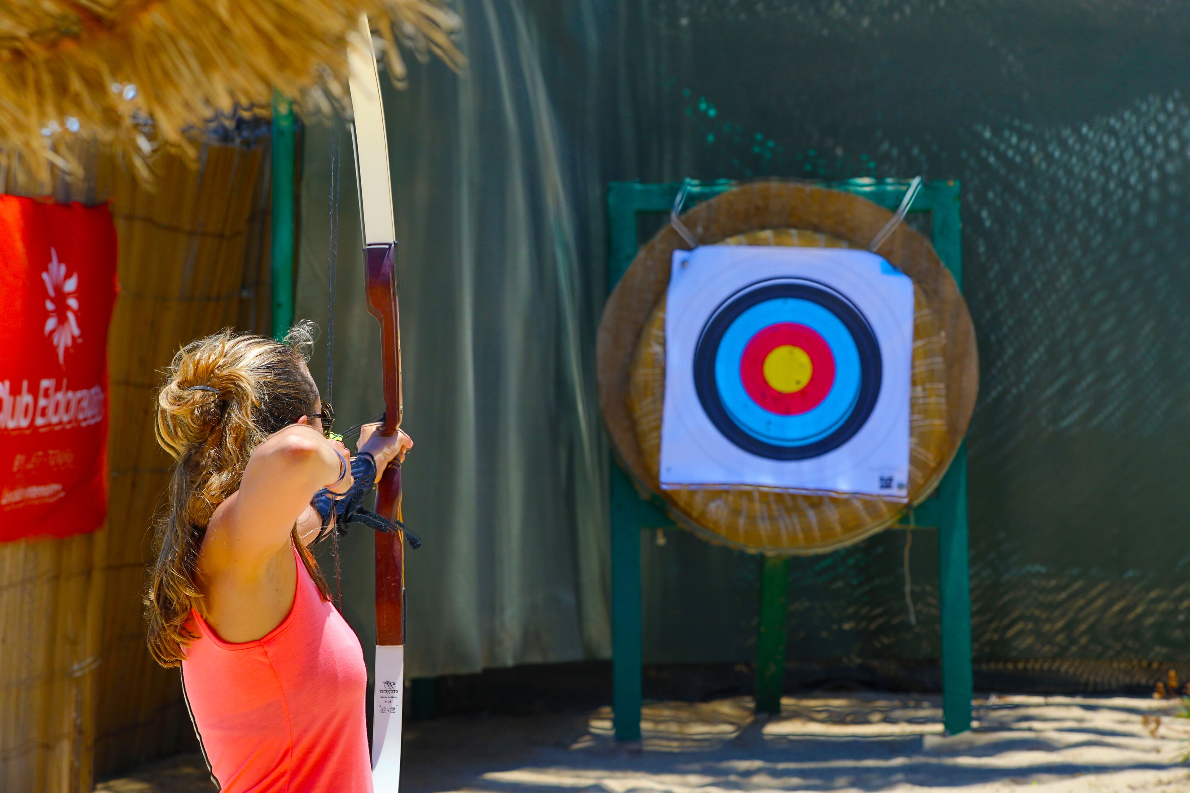 A person aiming an arrow at a target.