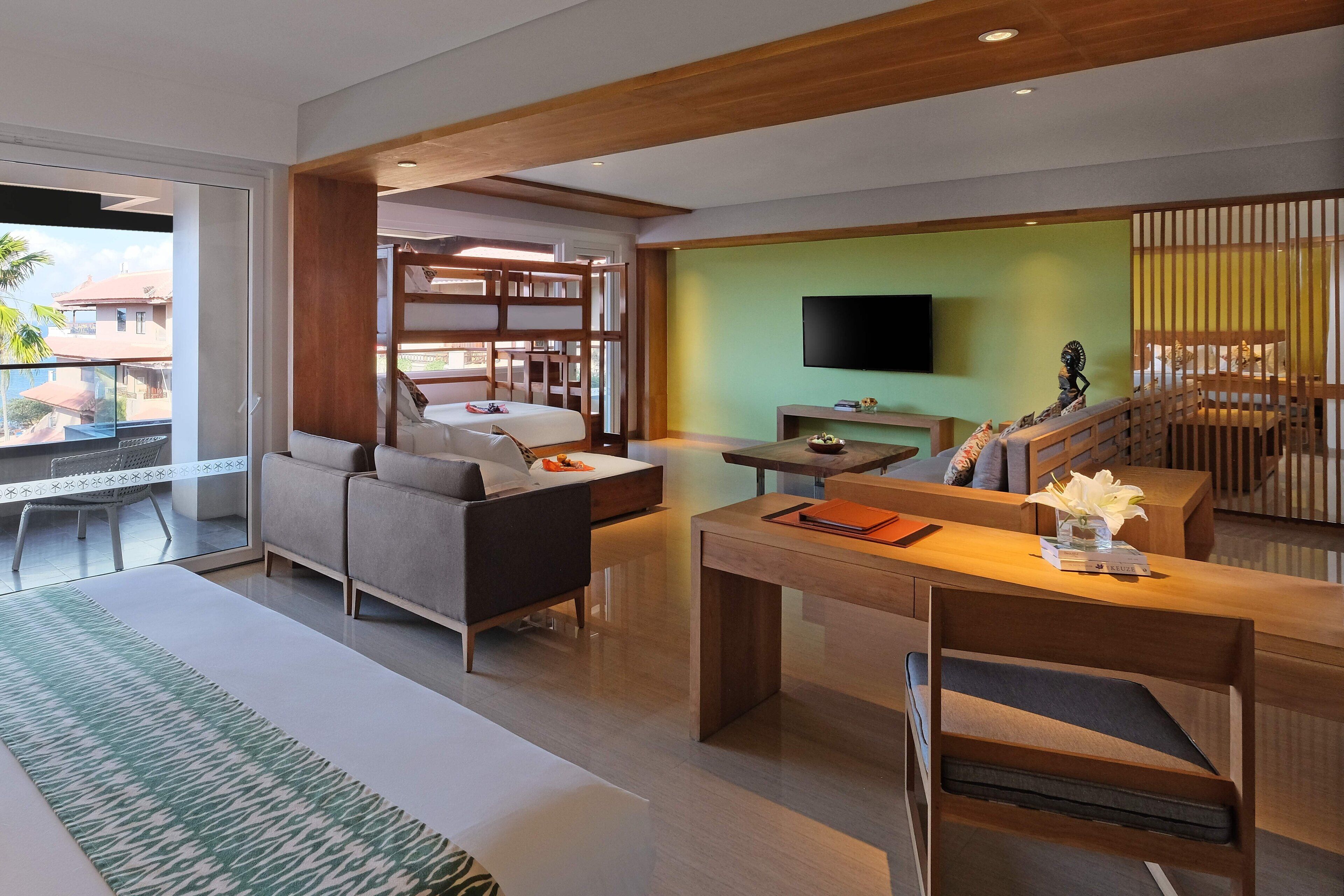 Una sala de estar moderna con un sofá, una mesa de comedor y un televisor montado en la pared.