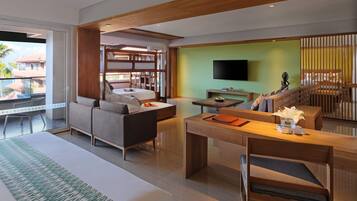 A modern living room with a sofa, a dining table, and a TV mounted on the wall.