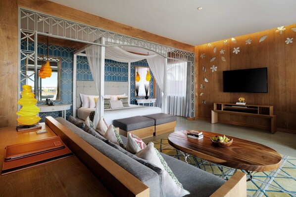 A modern hotel room with a large bed, a sofa, a TV, and a dining area.