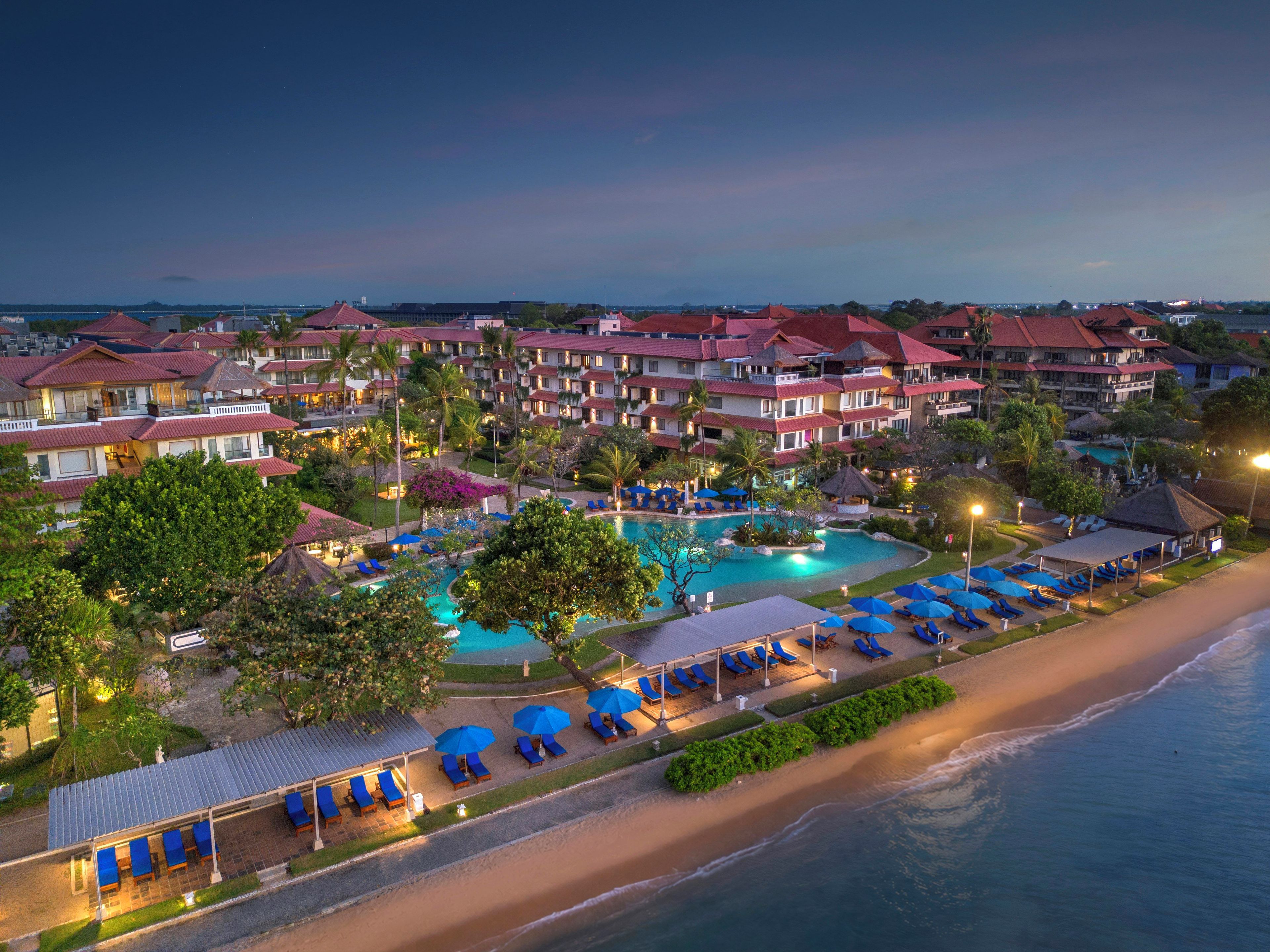 Un resort con varias edificaciones, piscina y zona de playa.