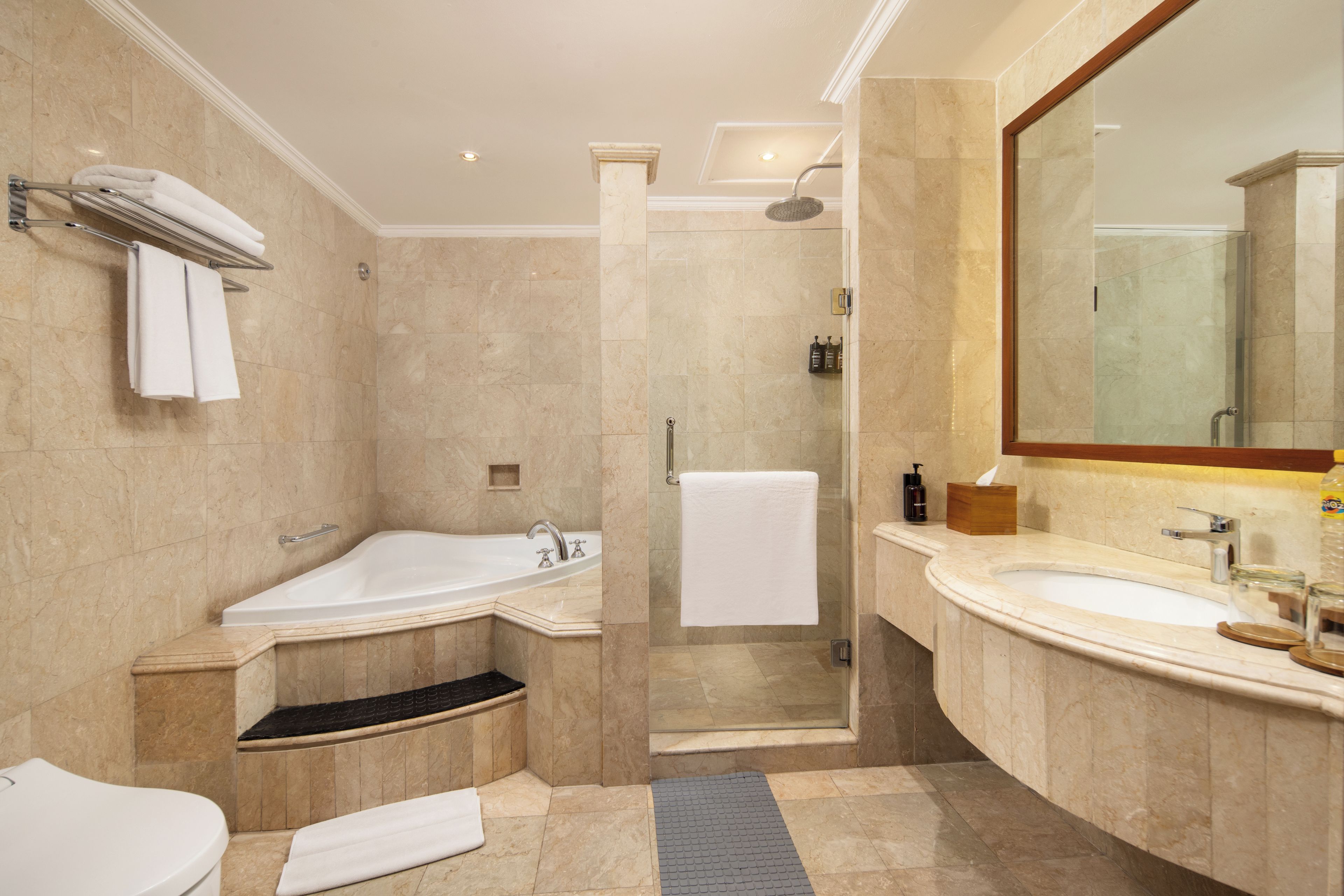 A modern bathroom with a bathtub, shower, and separate sink area.