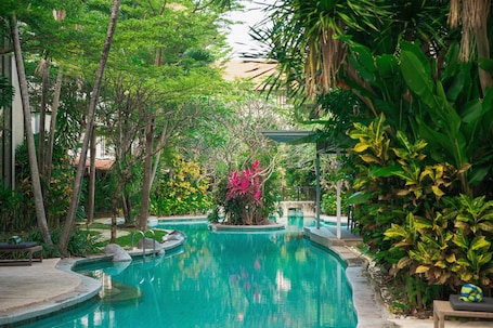 Una piscina al aire libre, sillones reclinables de piscina