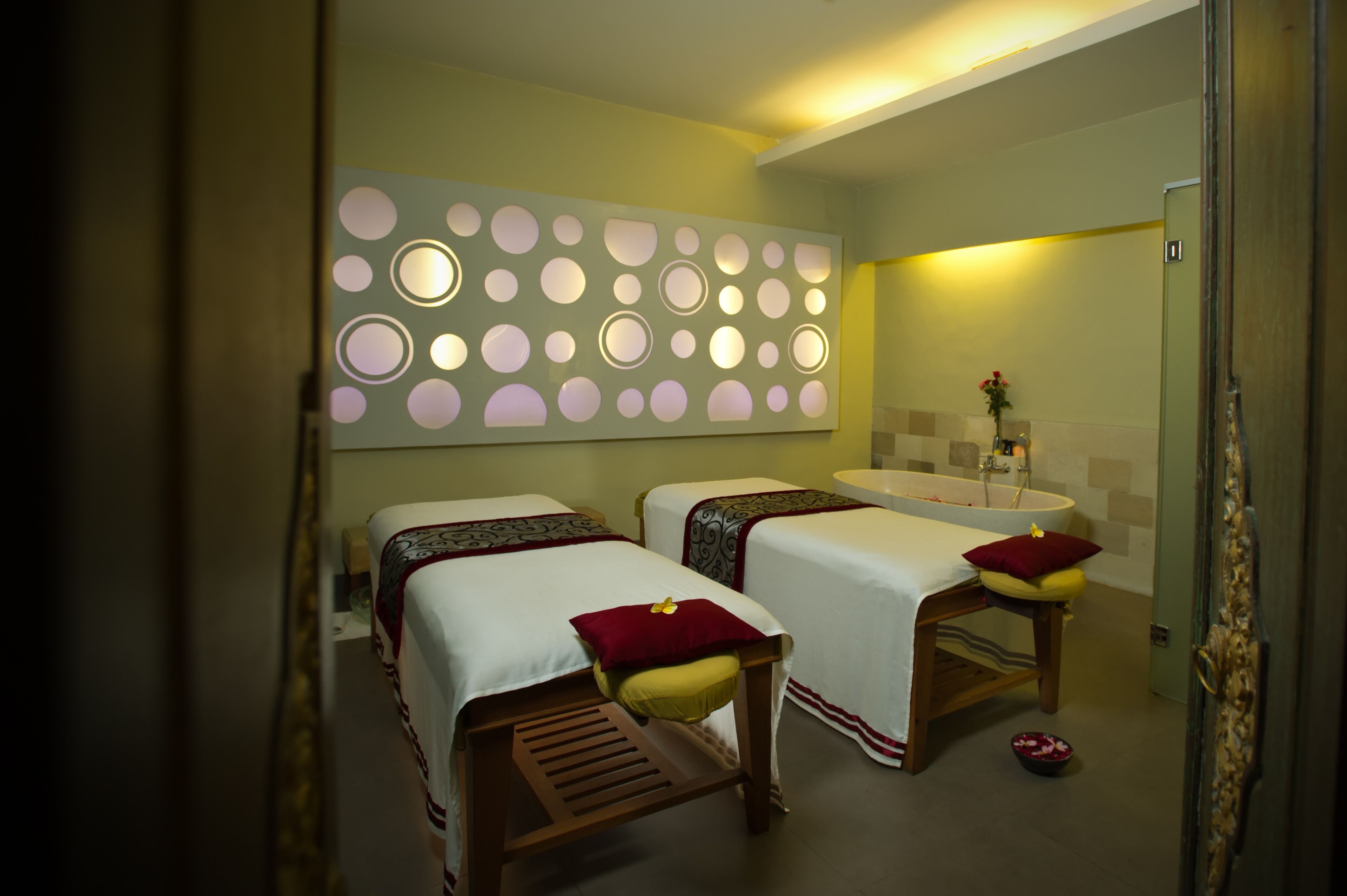 Habitación de hotel con dos camas, un baño y un detalle decorativo en la pared.