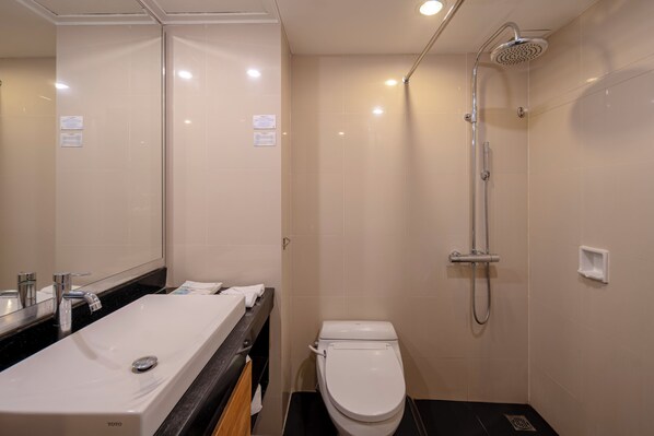 A modern bathroom with a sink, toilet, and shower. - Prime Plaza Hotel Sanur - Bali (Denpasar)