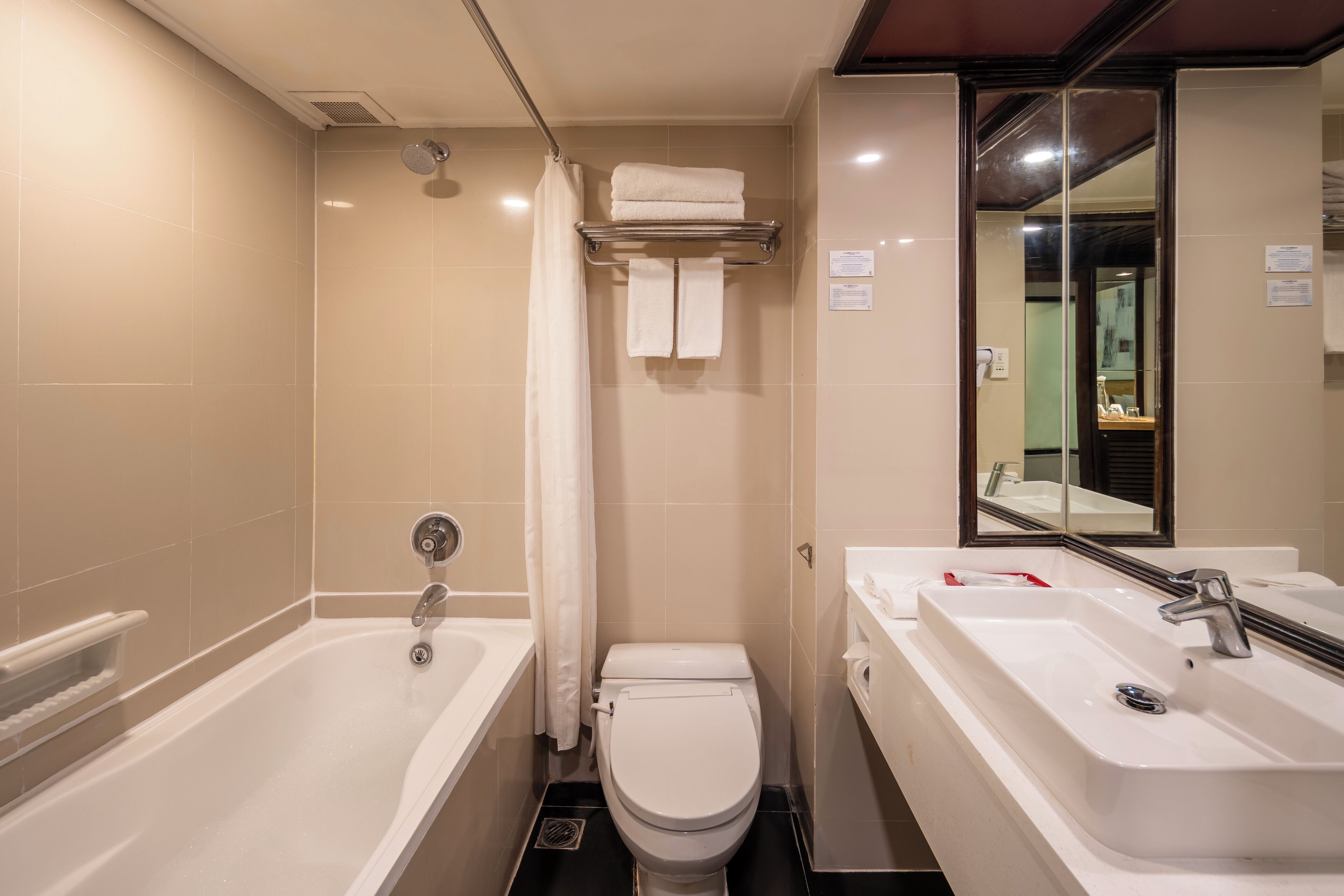 Une salle de bain moderne équipée d’une baignoire, de toilettes et d’un lavabo.