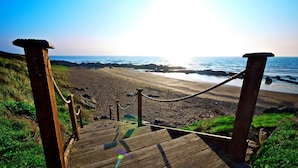 A wooden staircase leading to a beach with a view of the ocean. - Shoreline Hotel (Donabate)