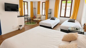 A hotel room with two beds, a TV, a desk, and a chair.