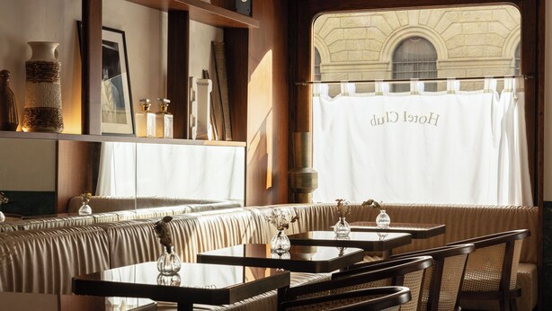 A cozy restaurant with wooden furniture, a cushioned bench seating area, and a view through a window with a curtain displaying "Hotel Cluj". - c-hotels Club (Florence)