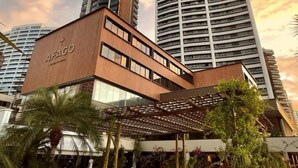 A modern hotel with a prominent 'AFACCO' sign, surrounded by high-rise buildings and a clear sky. - Afago Mareiro Hotel (Fortaleza)